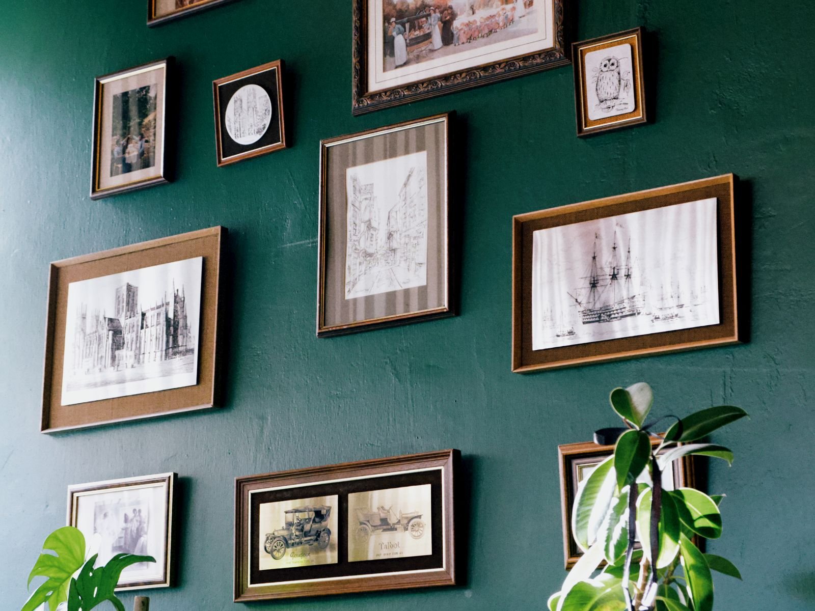 Deep green feature wall hung with framed prints