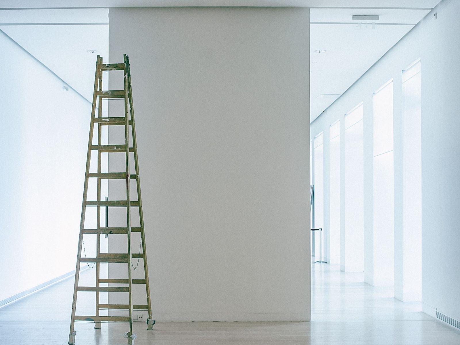 Empty, freshly painted room with stepladder, ready for handover